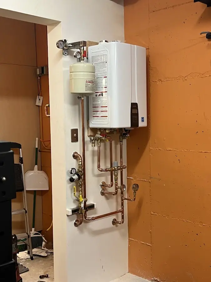 Plumbing technician inspecting water heater connections in Dry Run